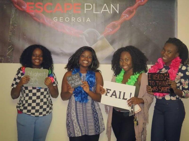 4 grils with funny sings after their escape room experience