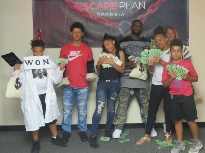 Young group of kids with money in their hands after bank heist escape room